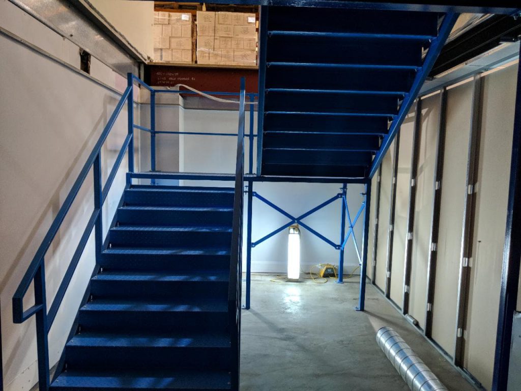 A blue mezzanine staircase for a new mezzanine floor in a warehouse
